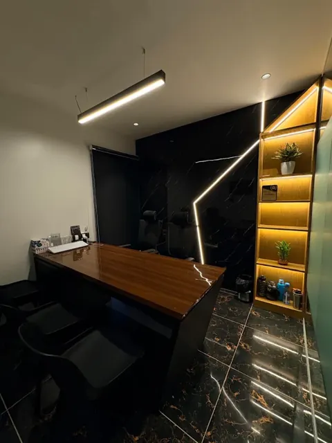 Private office room with a wooden desk and lit shelving