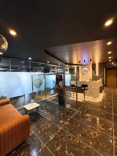 Reception area with an orange sofa, glass partitions and the marble-finish desk